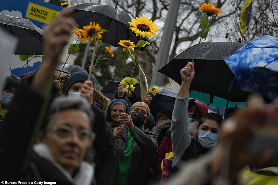 People hold sunflowers, the Ukrainian national flower, during a demonstration in support of Ukraine in Madrid
